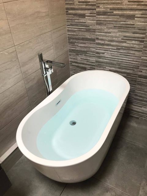 A contemporary bathroom with a feature décor wall — finished