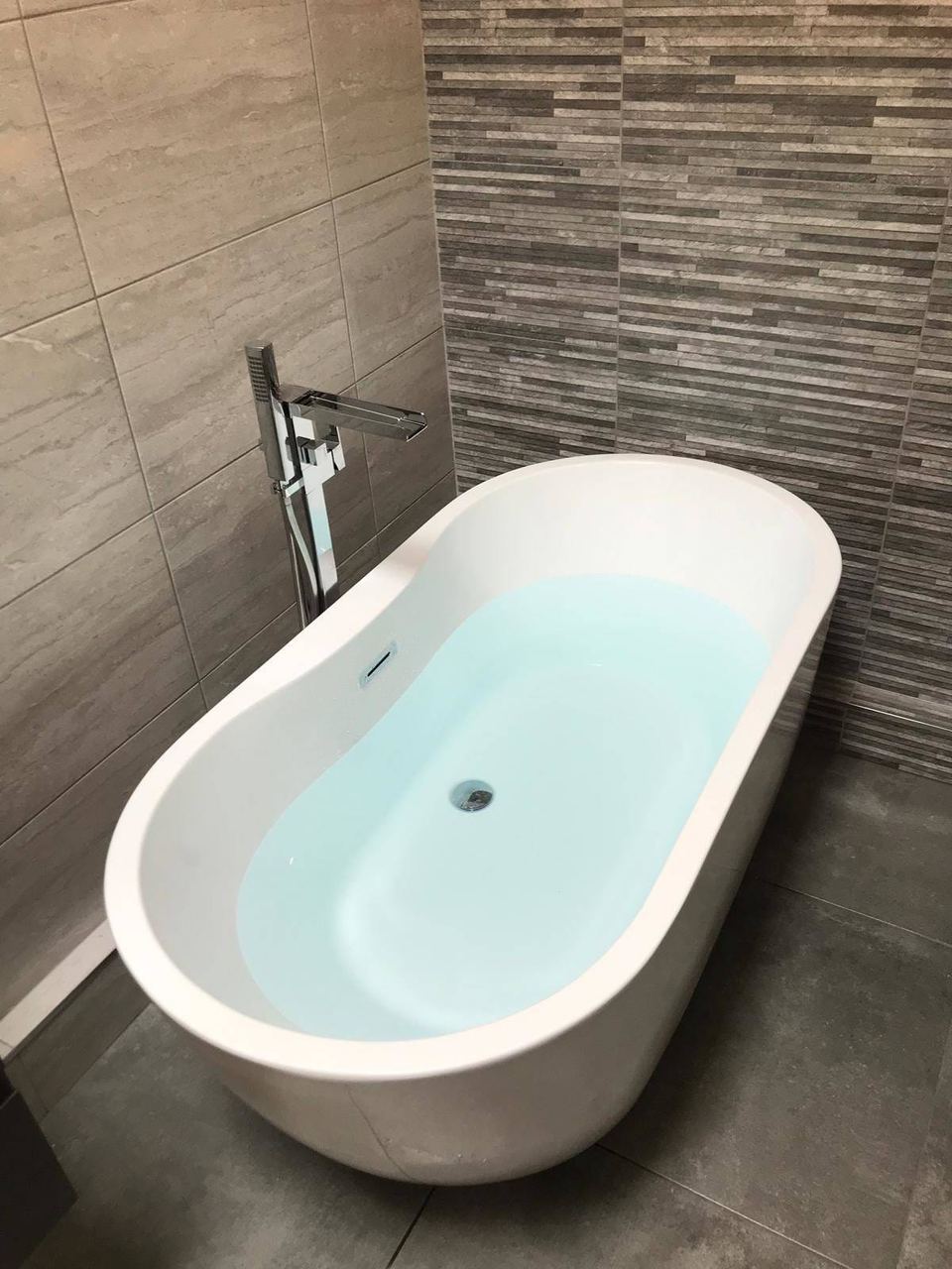 A contemporary bathroom with a feature décor wall — finished