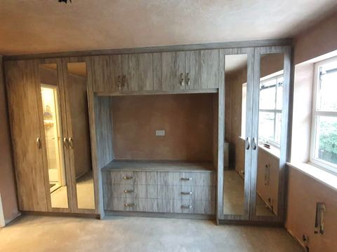 Full-wall fitted bedroom storage with a television recess — finished