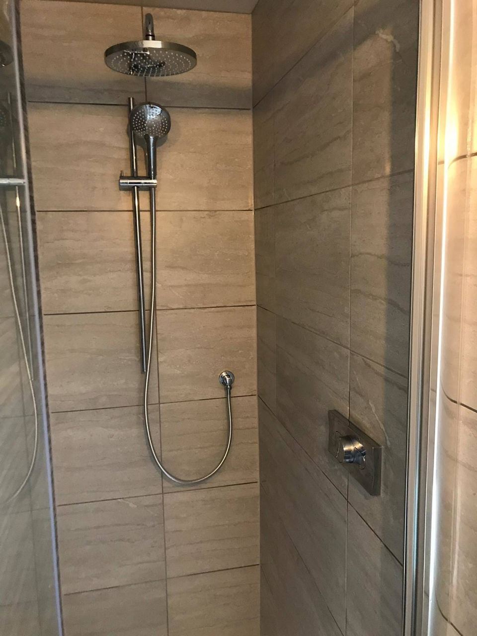 A contemporary bathroom with a feature décor wall — finished