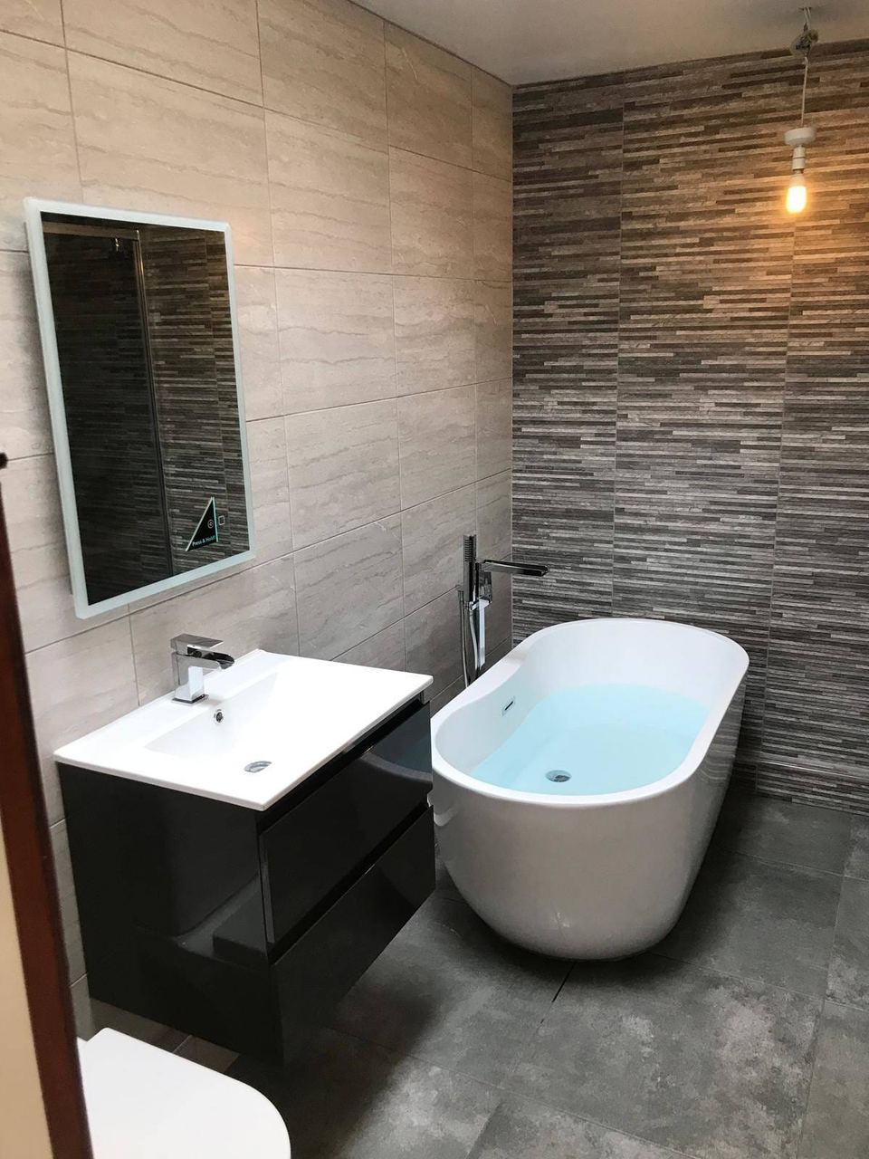 A contemporary bathroom with a feature décor wall — finished