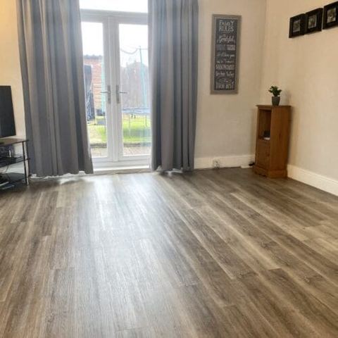 Flooring through a kitchen, dining room and living room — finished