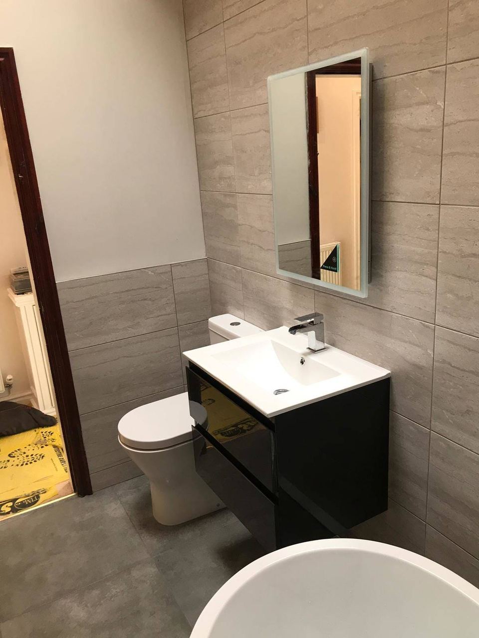 A contemporary bathroom with a feature décor wall — finished