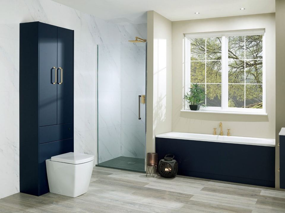 A navy bathroom with marble walls and gold fittings