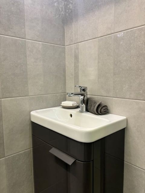 Kian Pearl ceramic tiles fitted in a room, grey, gloss & polished