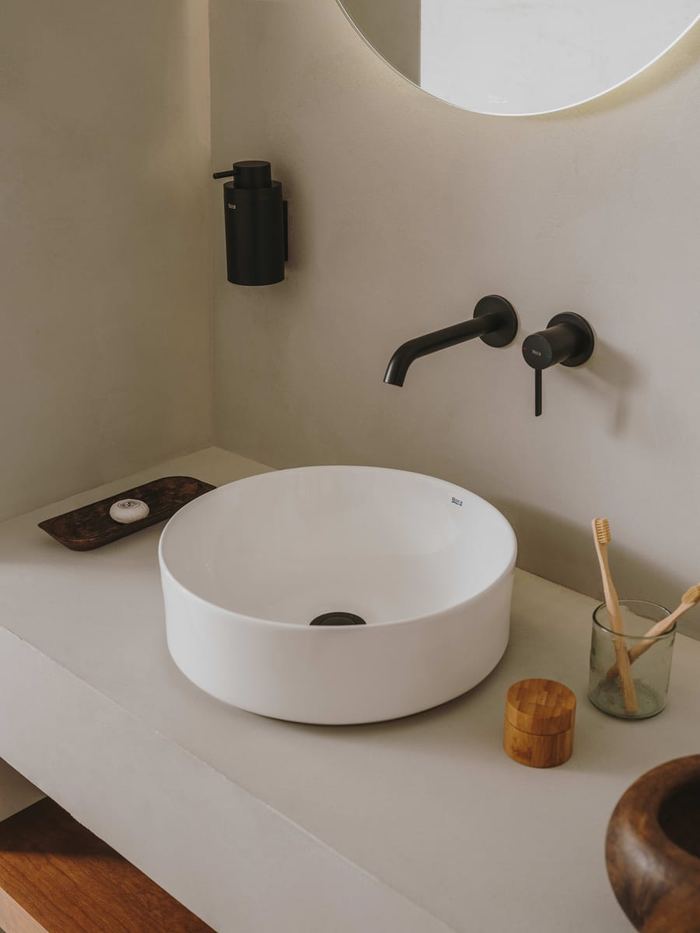 Ona round countertop basin with a black wall-mounted tap