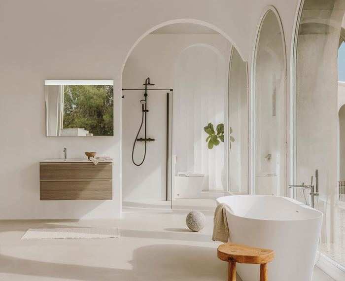 The Gap wall-hung unit in City Oak in an arched bathroom with a freestanding bath