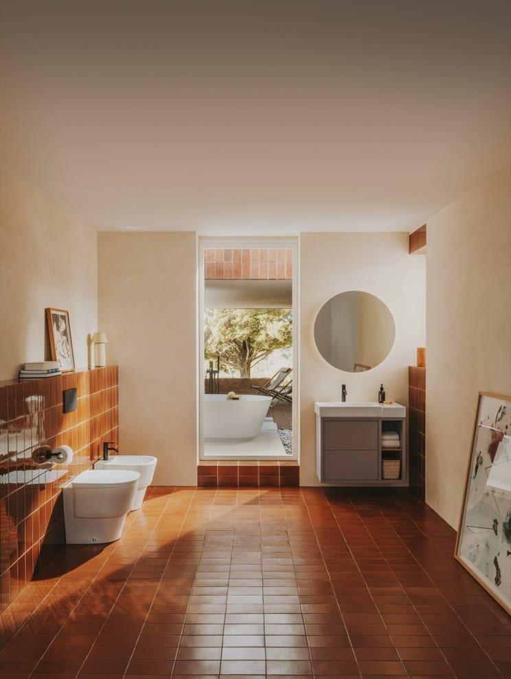 Tura wall-hung unit with a round mirror in a terracotta-floored room