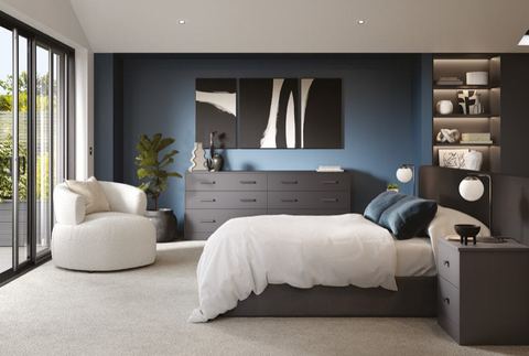 A modern bedroom with dark matte fitted wardrobes, drawers and shelving
