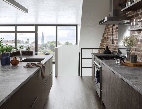 A modern dark woodgrain kitchen with an island and a range cooker